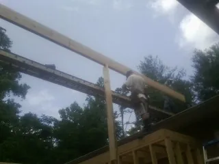 Carpenter setting a ridge beam over a new addition frame — Ice Dam Removal by Roofing Brothers in Spanaway