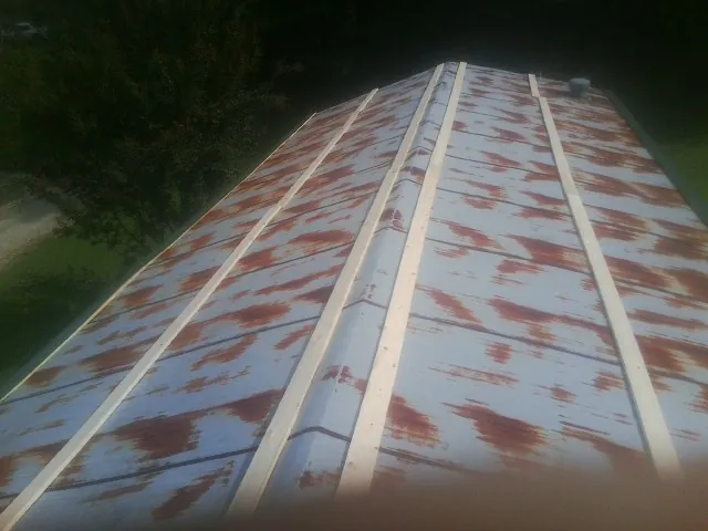 Rusted metal roof panels with new wood purlins before replacement — Storm Damage Roof Repair in Spanaway by Roofing Brothers
