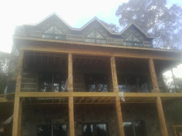 Dormers and porch framing on a large log home under construction — Roof Coating work by our crew in Spanaway